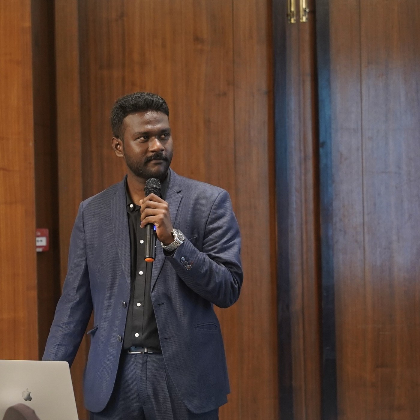 Close portrait of Naveen speaking into a wireless microphone during a session at Courtyard by Marriott, Mahabaleshwar.