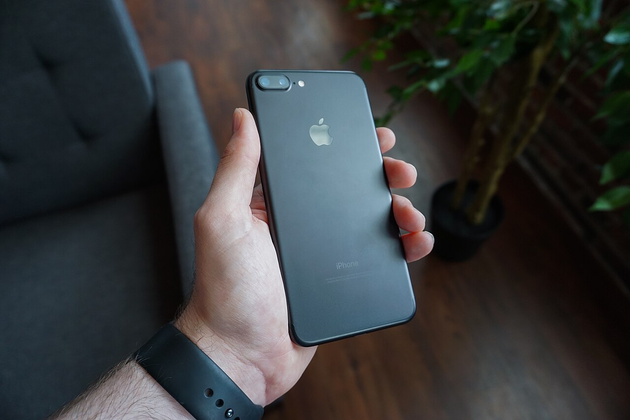 A hand holding a black smartphone